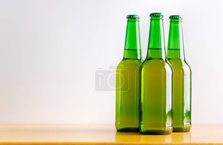 Téléchargez les photos : Bière au bar : Bouteilles sur une table en bois. Avec espace de copie - en image libre de droit