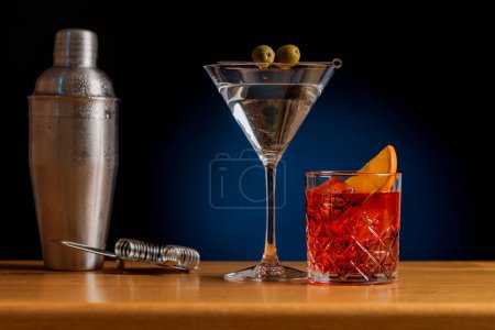 Foto de Atractivo cóctel: Bebidas maravillosamente arregladas en una mesa de bar con coctelera - Imagen libre de derechos
