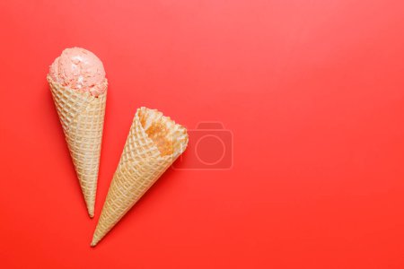 Téléchargez les photos : Glace pastèque dans de délicieux cônes de gaufres. Sur fond rouge avec espace de copie, pose plate - en image libre de droit