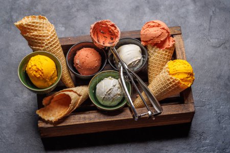 Téléchargez les photos : Saveurs variées de crème glacée dans de délicieux cônes de gaufres, un régal pour tous les papilles. Sur fond de pierre - en image libre de droit