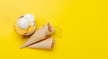 Photo for Assorted ice cream flavours and delightful waffle cones, a treat for every taste bud. Over yellow background with copy space, flat lay - Royalty Free Image