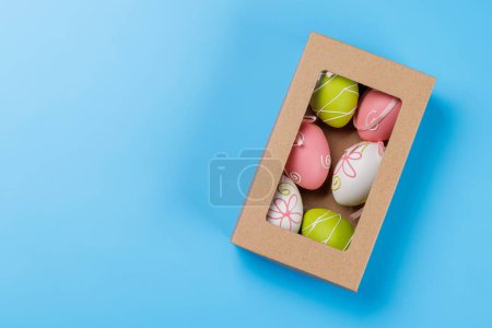 Photo for Easter delights: Colorful eggs in a gift box. Flat lay with copy space - Royalty Free Image
