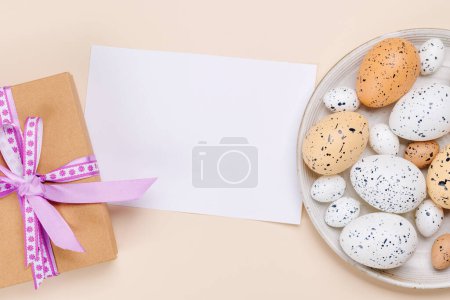 Téléchargez les photos : Délices de Pâques : œufs colorés dans un arrangement festif et boîte cadeau. Pose plate avec espace de copie de carte - en image libre de droit