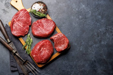 Photo for Raw beef fillet steaks on a cutting board, fresh and uncooked. Flat lay with copy space - Royalty Free Image