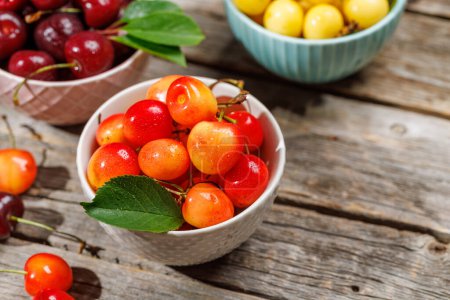 A vibrant and colorful cherry, bursting with sweet juiciness. On sunny outdoor garden table