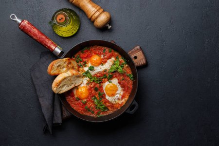 Téléchargez les photos : Délicieux petit déjeuner shakshuka dans une casserole. Pose plate avec espace de copie - en image libre de droit