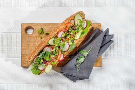 Foto de Delicioso sándwich vegetariano relleno en una baguette fresca, rebosante de sabor e ingredientes saludables. Puesta plana - Imagen libre de derechos