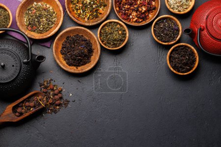 Téléchargez les photos : Une collection de différents thés nichés dans des bols en bois. Pose plate avec espace de copie - en image libre de droit