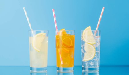 Téléchargez les photos : Diverses limonades avec glace dans des verres sur fond bleu - en image libre de droit