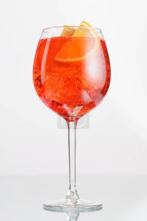 Aperol spritz cocktail with orange slice and ice on grey background