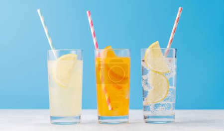 Photo for Various lemonade with ice in glasses over blue background - Royalty Free Image