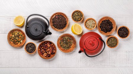 Téléchargez les photos : Une collection de différents thés nichés dans des bols en bois. Pose plate - en image libre de droit