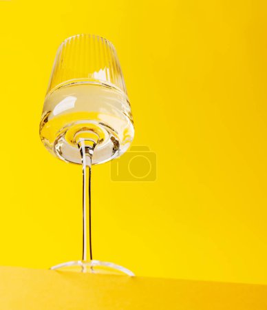 Foto de Elegancia del champán: copa con vino espumoso sobre un vibrante fondo amarillo. Con espacio de copia - Imagen libre de derechos