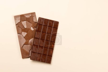 Sweet temptation: Chocolate bars on beige background with copy space