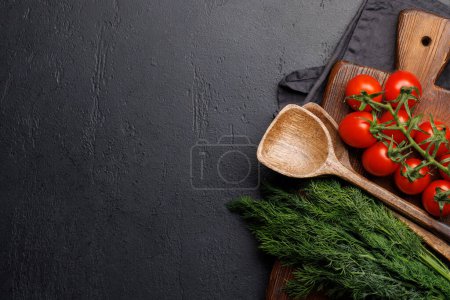 Escena de cocción: Tomates cherry, hierbas y especias en la mesa. Piso con espacio de copia