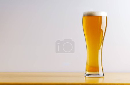 Foto de Cerveza en la barra: Refrescante cerveza de barril en una mesa de madera. Con espacio de copia - Imagen libre de derechos