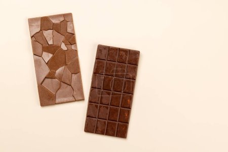 Sweet temptation: Chocolate bars on beige background with copy space