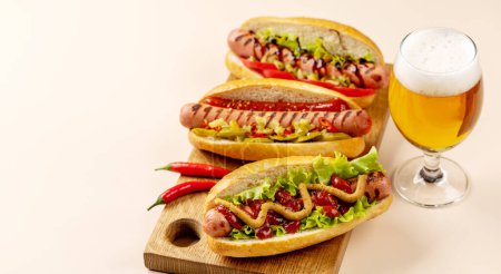 Foto de Various hot dog and beer. Homemade hotdogs on cutting board. With copy space - Imagen libre de derechos