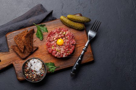Photo for Savory beef tartare with pickled gherkins and brown bread toasts. Flat lay with copy space - Royalty Free Image