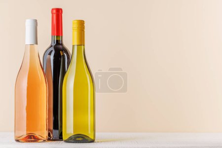Foto de Botellas de vino tinto, rosa y blanco en la mesa con espacio para copiar - Imagen libre de derechos