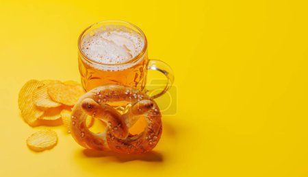 Foto de Cerveza, patatas fritas y pretzel. Sobre fondo amarillo con espacio de copia - Imagen libre de derechos