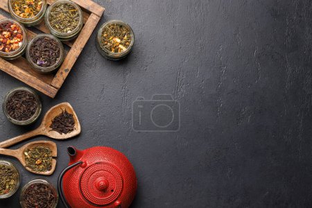 Foto de Surtido de la hora del té: Varias hojas de té seco y tetera. Piso con espacio de copia - Imagen libre de derechos