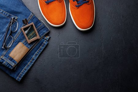 Photo for Men's Clothing on stone Background: Jeans, Sneakers, Perfume, Flat Lay with Copy Space - Royalty Free Image