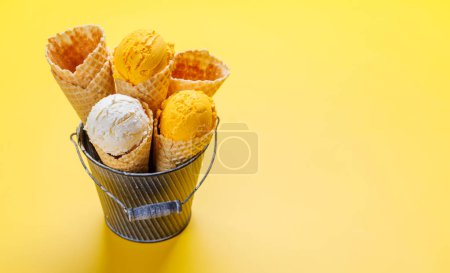 Téléchargez les photos : Glace au citron dans de délicieux cônes de gaufres, un régal pour tous les papilles. Sur fond jaune avec espace de copie - en image libre de droit