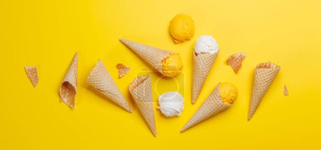 Photo for Assorted ice cream flavours in delightful waffle cones, a treat for every taste bud. Over yellow background, flat lay - Royalty Free Image