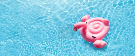 Photo for Pink flamingo inflatable ring in sunny pool. Summer vacation with copy space - Royalty Free Image