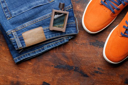 Vêtements pour hommes sur fond en bois : Jeans, Baskets, Parfum, Couche plate avec espace de copie