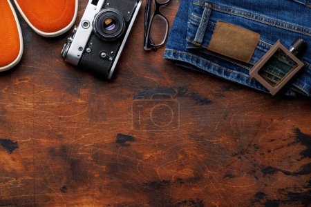 Photo for Men's Clothing on wooden Background: Jeans, Sneakers, Eyeglasses, Flat Lay with Copy Space - Royalty Free Image