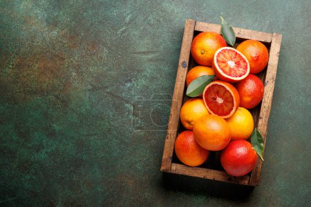 Téléchargez les photos : Oranges rouges fraîches en caisse de bois. Pose plate avec espace de copie - en image libre de droit