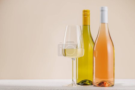 Foto de Botellas de vino blanco y rosa en la mesa con espacio para copiar - Imagen libre de derechos