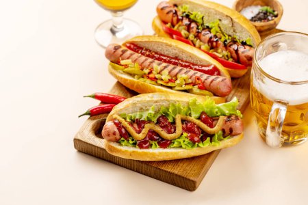 Téléchargez les photos : Divers hot dog et bière. Hotdogs faits maison sur planche à découper. Avec espace de copie - en image libre de droit