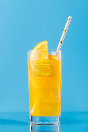 Photo for Lemonade with ice in glass over blue background - Royalty Free Image