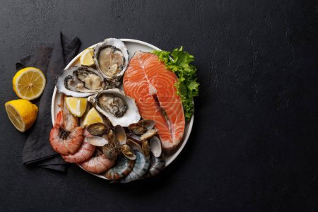 Téléchargez les photos : Plat de fruits de mer délice : Crevettes, saumon, huîtres à gogo. Pose plate avec espace de copie - en image libre de droit