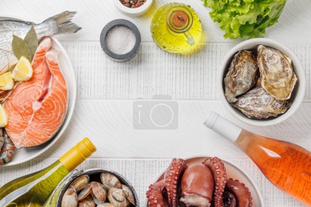Foto de Delicia plato de mariscos: camarones, salmón, ostras en abundancia y botellas de vino. Con espacio de copia - Imagen libre de derechos