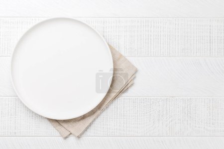 Empty plate on wooden table, overhead view with copy space