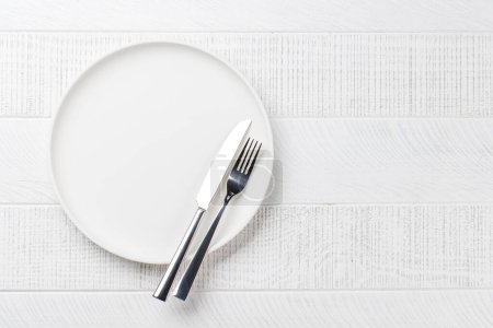 Téléchargez les photos : Assiette vide, fourchette et couteau sur table en bois, vue aérienne avec espace de copie - en image libre de droit
