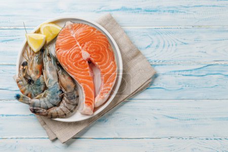 Téléchargez les photos : Plat de fruits de mer Délice : Crevettes et saumon. Pose plate avec espace de copie - en image libre de droit