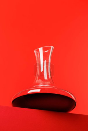 Red wine elegance: Decanter against a vibrant red background. With copy space