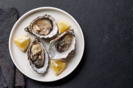 Photo for Fresh oysters with lemon on plate. Flat lay with copy space - Royalty Free Image