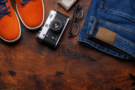 Photo for Men's Clothing on wooden Background: Jeans, Sneakers, Eyeglasses, Flat Lay with Copy Space - Royalty Free Image