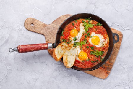 Photo for Delicious shakshuka breakfast in a pan. Flat lay - Royalty Free Image