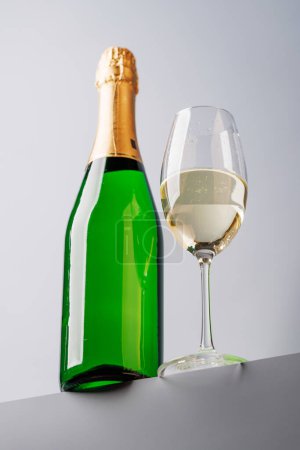 Champagner-Eleganz: Glas und Flasche vor grauem Hintergrund. Mit Kopierraum