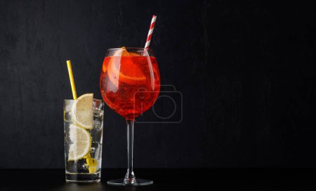 Aperol spritz and gin tonic cocktails on black with copy space