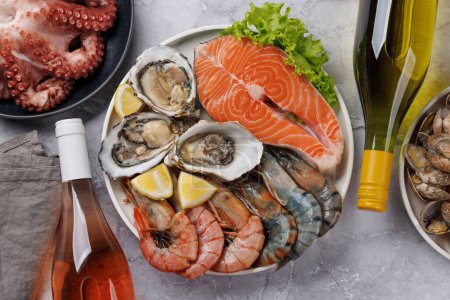 Photo for Seafood Platter Delight: Shrimps, Salmon, Oysters Galore. Flat lay with wine bottles - Royalty Free Image
