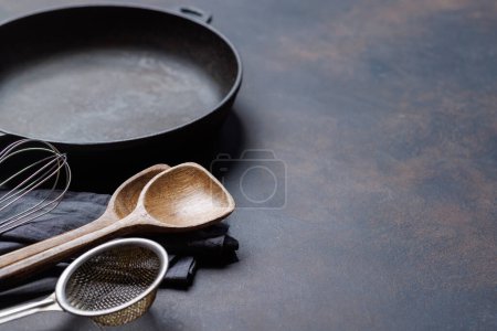 Esenciales culinarios: Diversos utensilios de cocina sobre mesa de piedra. Con espacio de copia
