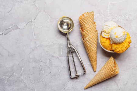 Foto de Surtido de sabores de helado y deliciosos conos de gofres, un regalo para todos los papilas gustativas. Sobre fondo amarillo con espacio de copia, plano - Imagen libre de derechos